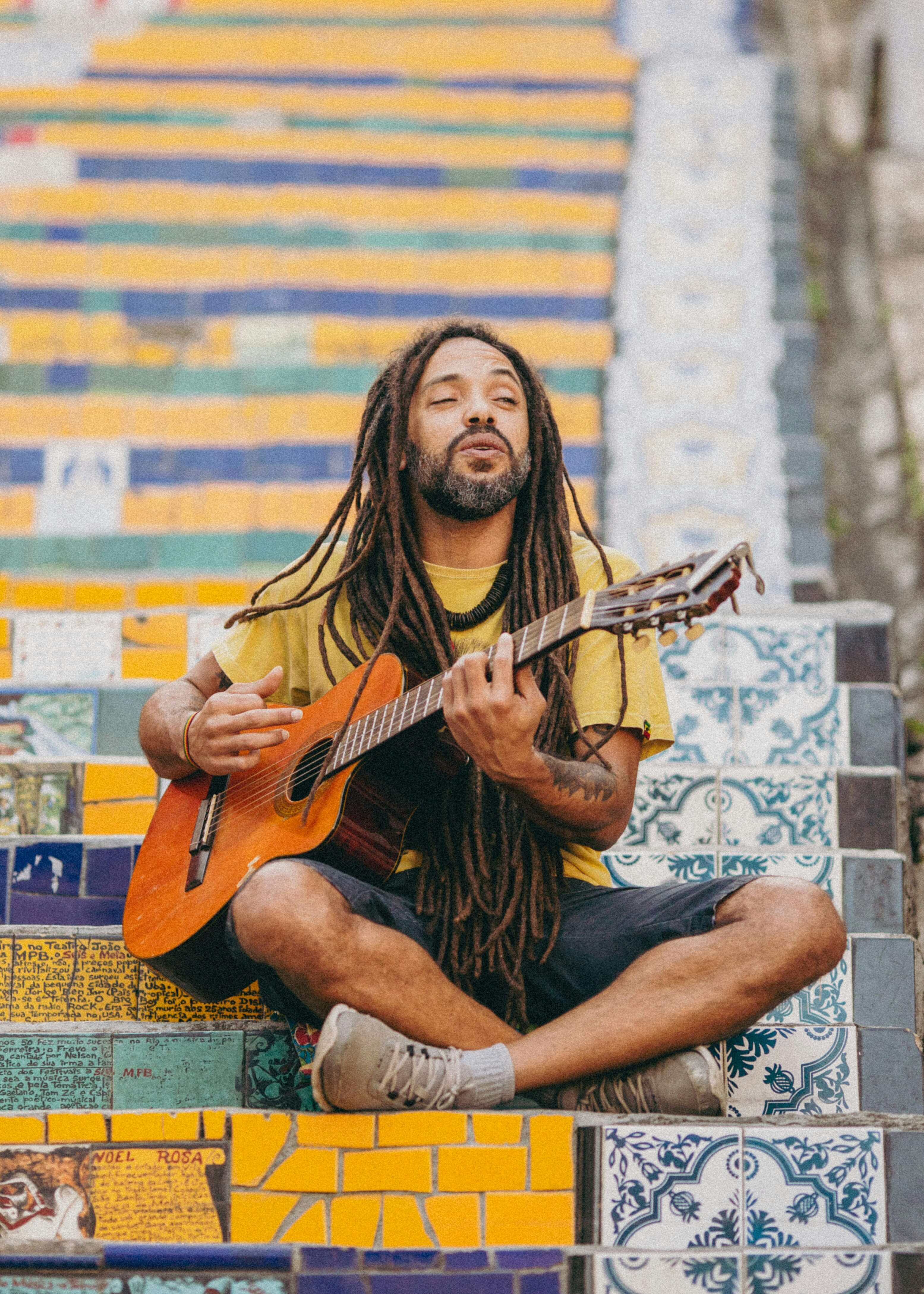 Man playing guitar alone, symbolizing the essence of a vibrant culture and music scene.